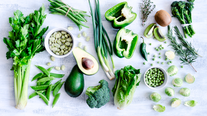 Apio, aguacate y pimiento verde sobre una mesa blanca